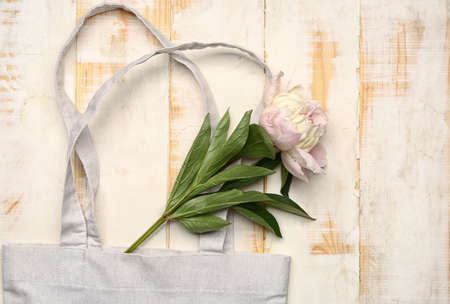 Eco bag and flowers on wooden background
