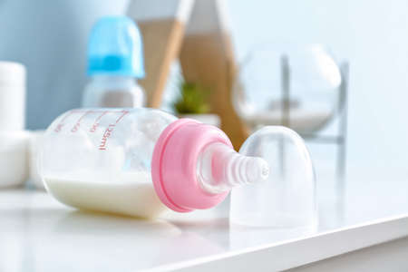 Bottle of milk for baby on table in roomの写真素材