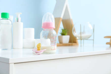 Bottle of milk for baby with pacifier on tableの写真素材