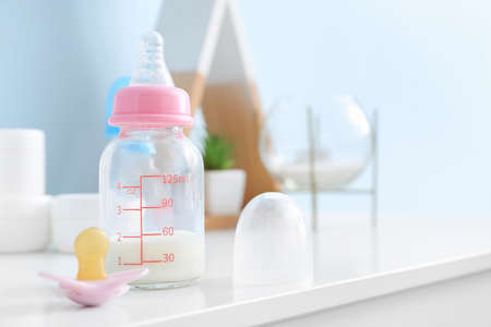 Bottle of milk for baby with pacifier on tableの写真素材