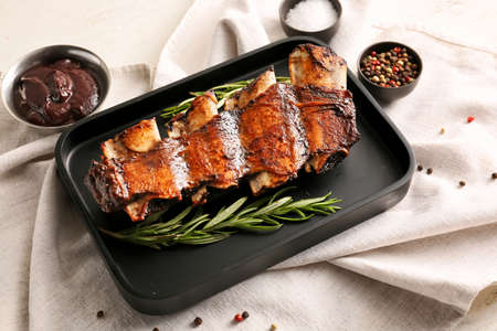 Tasty beef short ribs with sauce on tableの写真素材