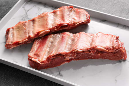 Raw beef short ribs on plate, closeupの写真素材