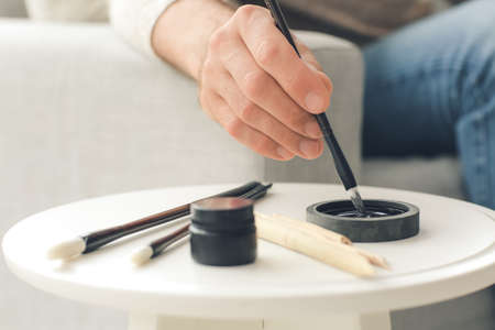 Senior male calligraphist working in office, closeupの写真素材