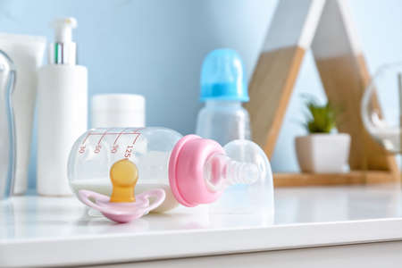 Bottle of milk for baby with pacifier on tableの写真素材