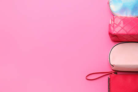 Bags with decorative cosmetics on color background