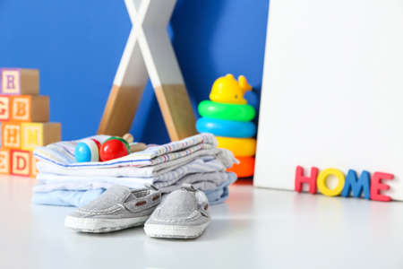 Children's toys with clothes on table in room