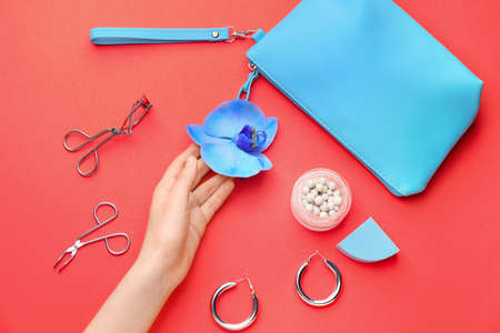 Female hand and set of decorative cosmetics on color backgroundの写真素材