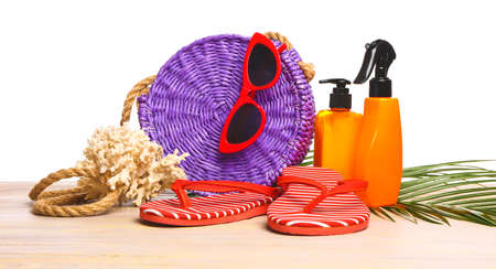 Set of beach accessories on table against white background