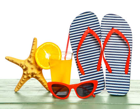 Set of beach accessories on table against white backgroundの写真素材