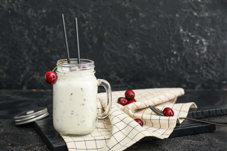 Mason of yogurt with berry and flax seeds on dark backgroundの写真素材