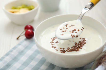 Bowl of yogurt and flax seeds on tableの写真素材