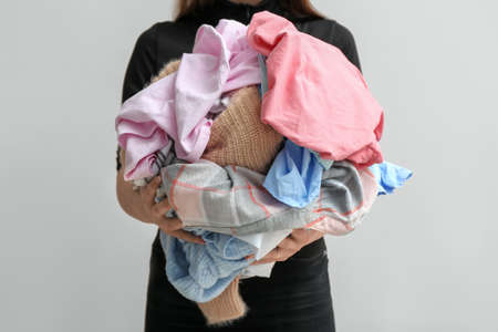 Woman with dirty clothes on light backgroundの写真素材