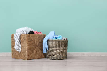 Baskets with dirty clothes near color wallの写真素材