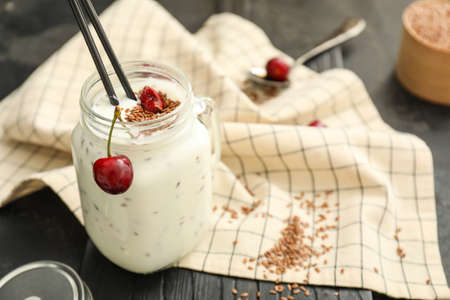 Mason of yogurt with berry and flax seeds on dark backgroundの写真素材