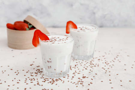 Glasses of yogurt with strawberry and flax seeds on white backgroundの写真素材