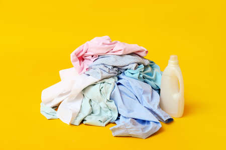 Dirty clothes and detergent on color backgroundの写真素材