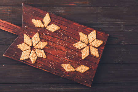 Board with cereal cookies and flax seeds on wooden backgroundの写真素材