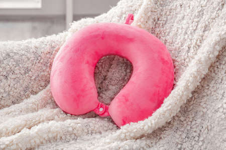 Travel pillow on armchair in roomの写真素材