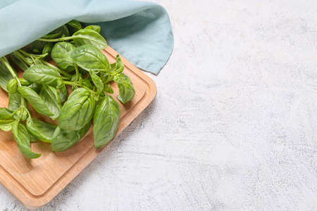 Board with fresh green basil on table