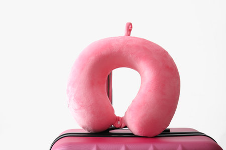 Travel pillow and suitcase on white backgroundの写真素材