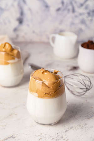 Glass of tasty dalgona coffee on white background