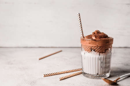 Glass of tasty dalgona coffee on light background