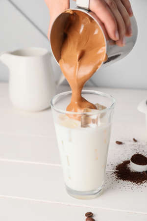 Woman preparing tasty dalgona coffee on tableの写真素材