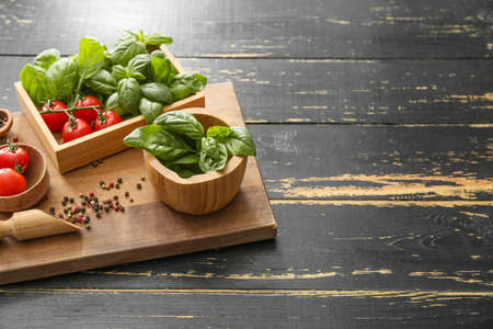 Fresh green basil, tomatoes and spices on tableの写真素材