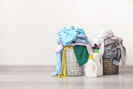 Baskets with dirty clothes near light wallの写真素材