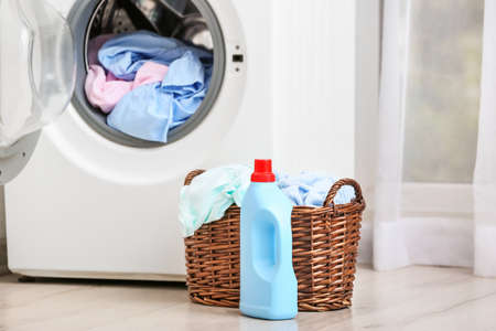 Washing machine with laundry in bathroomの写真素材