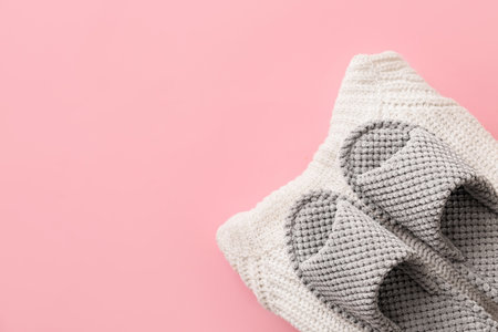 Pair of soft slippers and clothes on color backgroundの写真素材
