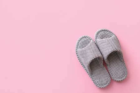 Pair of soft slippers on color backgroundの写真素材