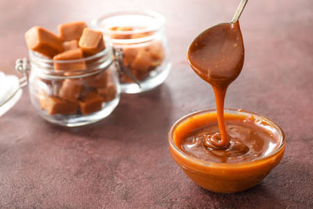 Bowl with liquid caramel on tableの写真素材