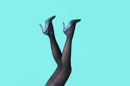 Beautiful young woman in tights on color backgroundの写真素材
