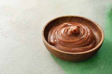 Bowl with liquid caramel on tableの写真素材