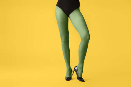 Beautiful young woman in tights on color backgroundの写真素材