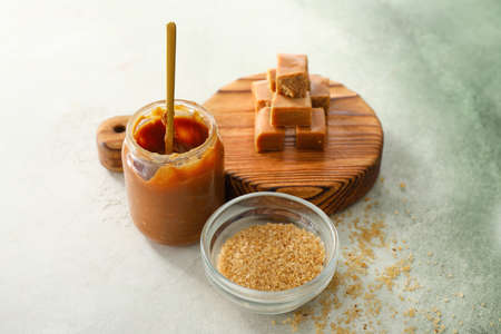 Composition with sweet caramel and sugar on tableの写真素材