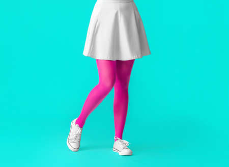 Beautiful young woman in tights on color backgroundの写真素材