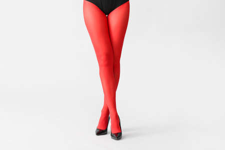 Beautiful young woman in tights on light background