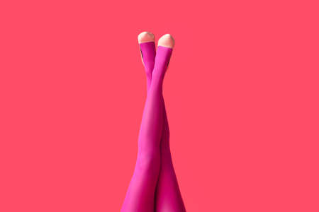 Beautiful young woman in tights on color backgroundの写真素材