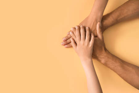 Hands of family on color backgroundの写真素材