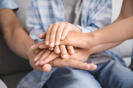 Family holding hands together at home, closeupの写真素材