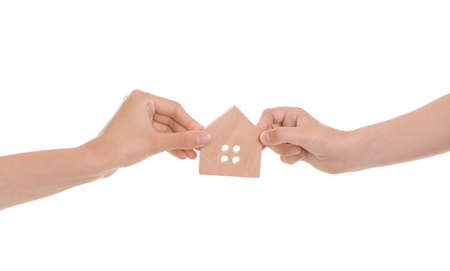 Hands of family with small house on white backgroundの写真素材