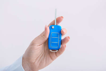 Female hand with car key on light backgroundの写真素材