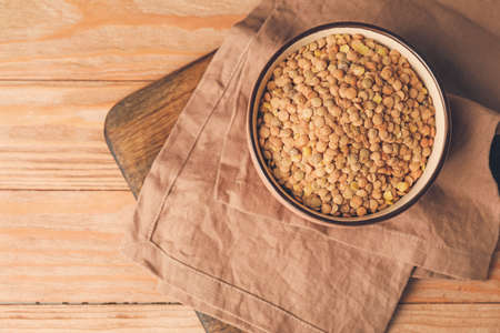 Raw lentils in bowl on tableの写真素材