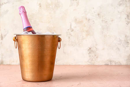 Bucket with ice and champagne on tableの写真素材