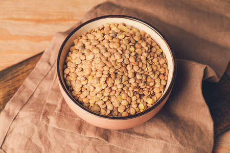 Raw lentils in bowl on tableの写真素材