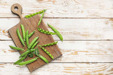 Board with tasty fresh peas on tableの写真素材