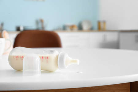 Bottle of milk for baby on table in kitchenの写真素材