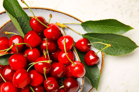 Bowl with sweet cherry on light background, closeupの写真素材